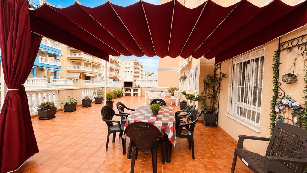 a patio with a table and chairs on a balcony at 2 bedroom flat 100m from the beach with huge terrace in Moncófar