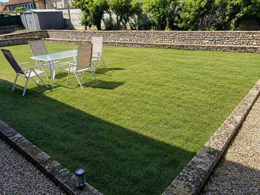a table and chairs sitting on a lawn at Maison avec jardin in Harquency