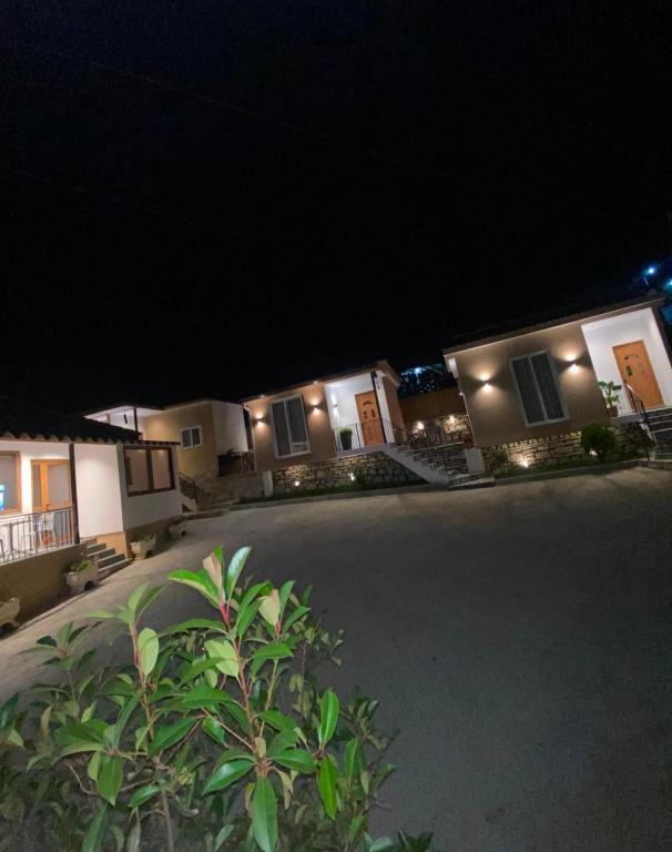 a couple of houses at night with a driveway at Vila Nakaj Guest House in Gjirokastër