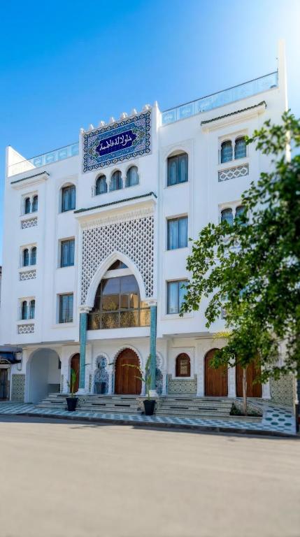 a large white building with a sign on it at Dar Lala Fatma in Le Lido