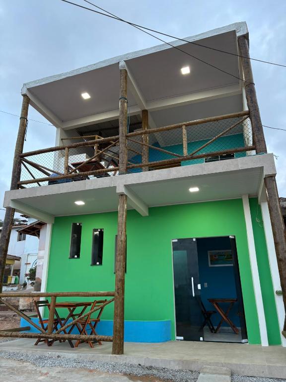 ein grünes Gebäude mit schwarzer Tür und Balkon in der Unterkunft Chalés do mar in Icapuí