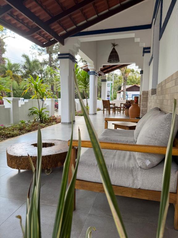 a bedroom with a bed and a patio with tables at Boulevard Pousada Boutique in Guaramiranga