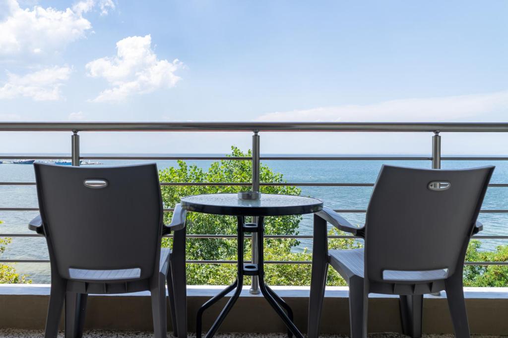 a table and two chairs on a balcony with the ocean at Akrogiali Studios Michaniona in Nea Michaniona
