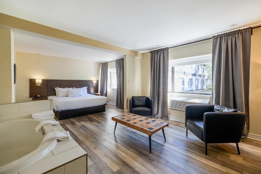 a hotel room with a bed and a bathroom at Hotel Newstar Montréal in Montreal