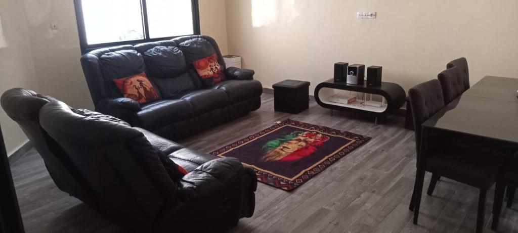 a living room with a leather couch and a table at Nakhili in Keur Massar