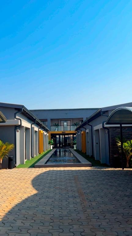 a large building with a courtyard with a pool at Impèrio Boutique Guest Lodge in Siyabuswa