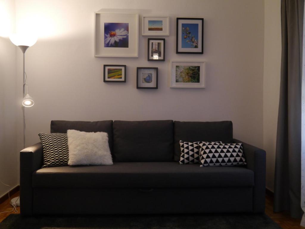 a couch in a living room with pictures on the wall at Apartamento Boavista in Vila Nova de Gaia