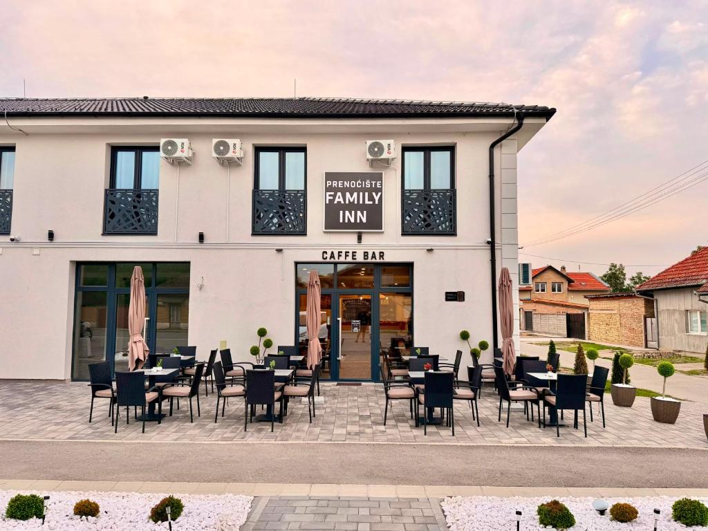 a restaurant with tables and chairs in front of a building at Family Inn in Subotica