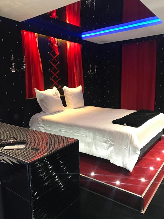 a bedroom with two beds with red and blue curtains at Le Cabaret Vip SPA in Lyon