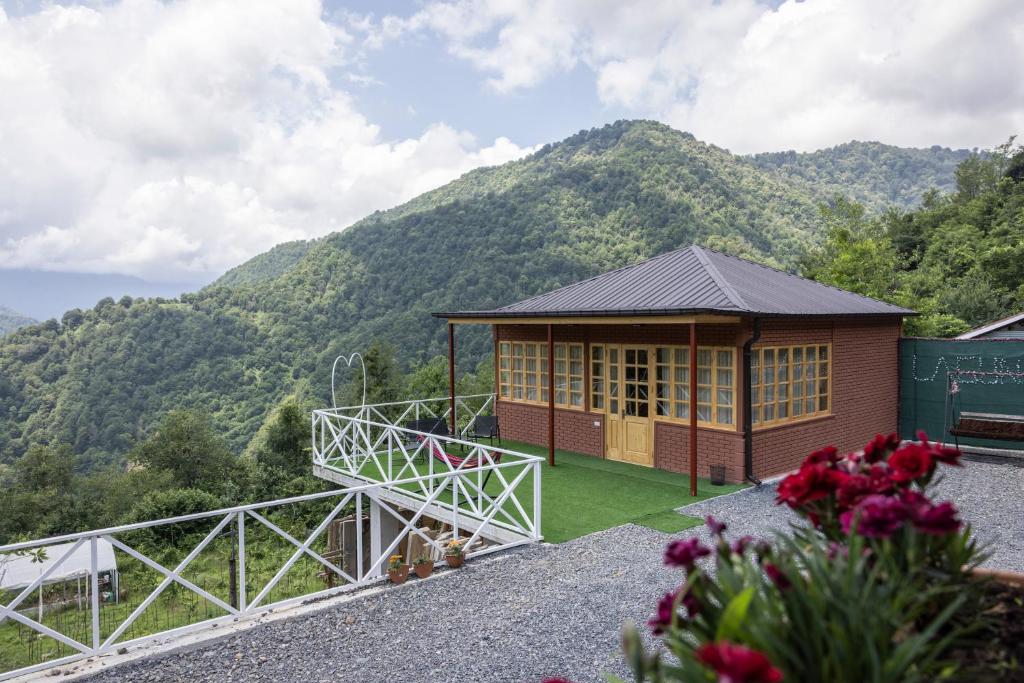 a small building with a mountain in the background at Laguna Villa Cottages in Chinkadzeebi