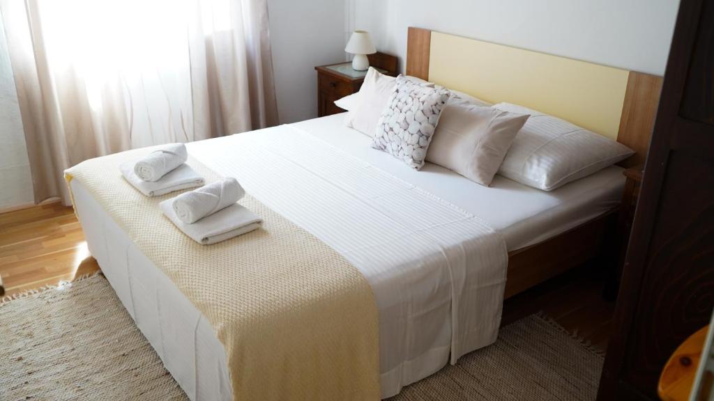 a bedroom with a large white bed with towels on it at Apartmani Vela Luka in Vela Luka