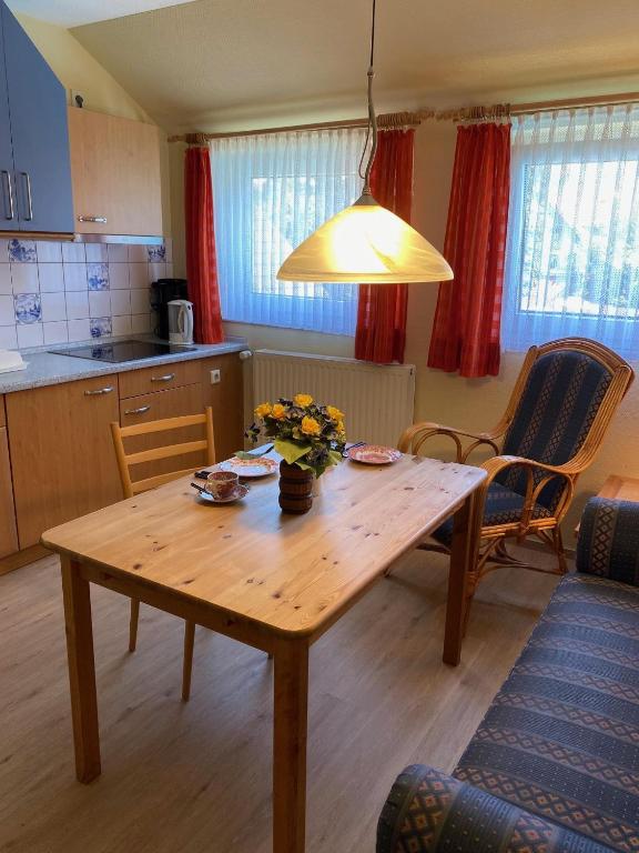 a kitchen with a wooden table with flowers on it at Nordsee 405 in Wangerooge