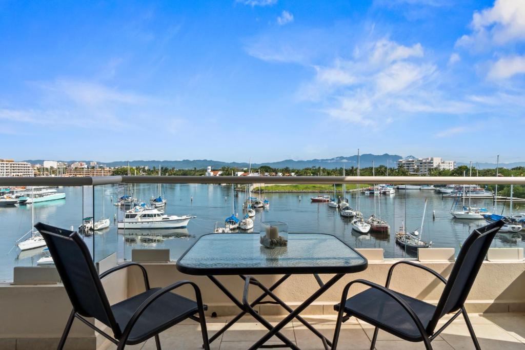 a table and chairs on a balcony with a marina at Marina Banderas Suites Hotel Boutique in Nuevo Vallarta