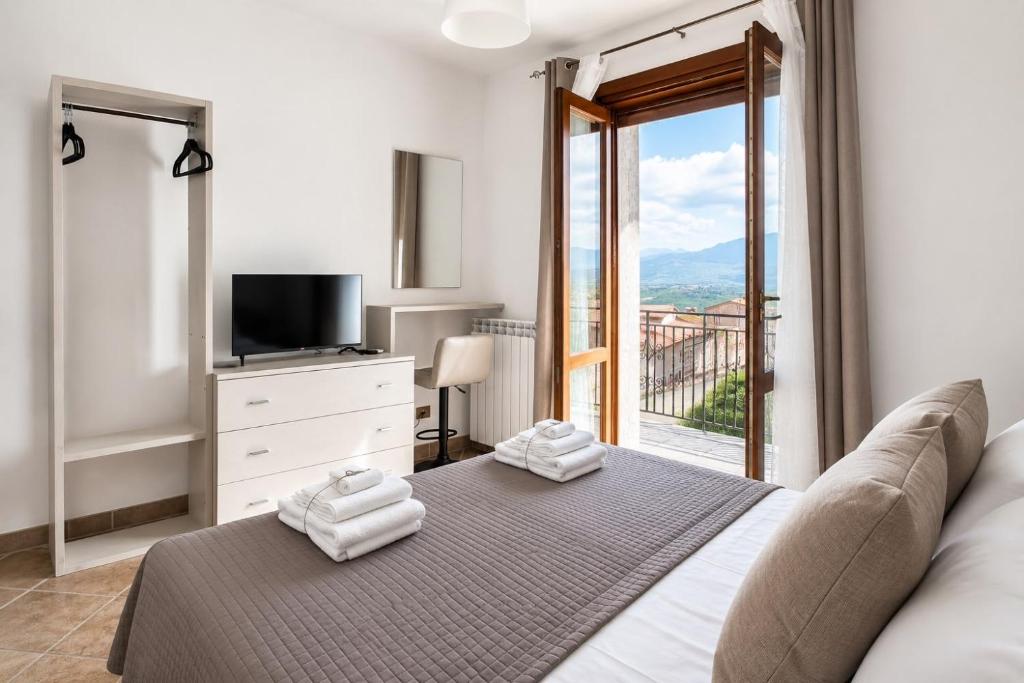 a bedroom with a bed and a tv and a window at Panorama Rooms in Gesualdo