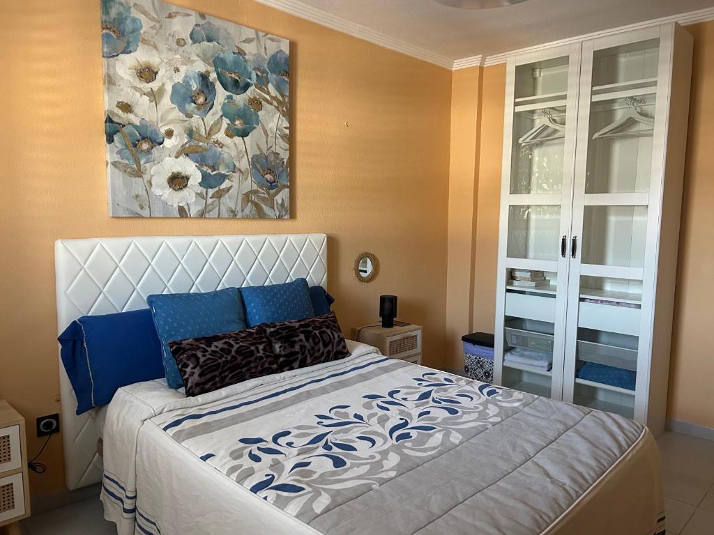 a bedroom with a bed with a painting on the wall at Habitación con baño privado in Gáldar
