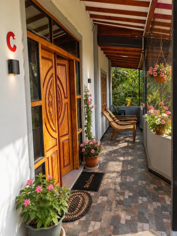 a front door of a house with potted plants at Cleopatra Rest House in Nilaveli