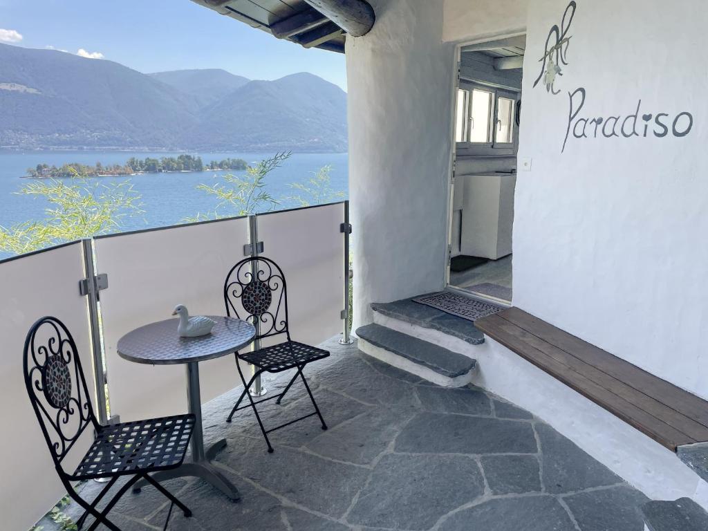 a table and chairs on a balcony with a view of the water at Al Paradiso by Fewotessin in Ronco sopra Ascona
