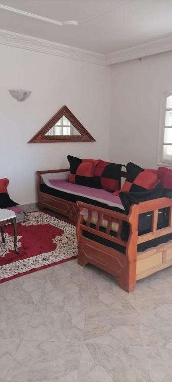 a living room with a bed and a couch at Maison Souad Guest House in Chott Meriem