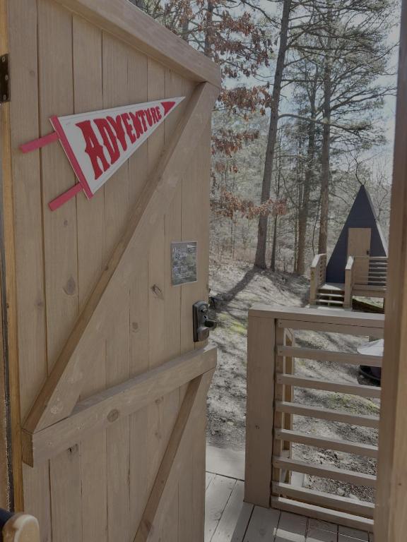 a wooden garage door with a sign on it at Loblolly Pines Adventure Aframe #1 in Eureka Springs