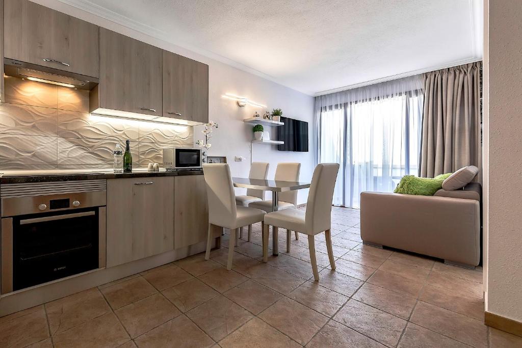a kitchen and living room with a table and a couch at Windsor Panoramic Las Americas in Adeje