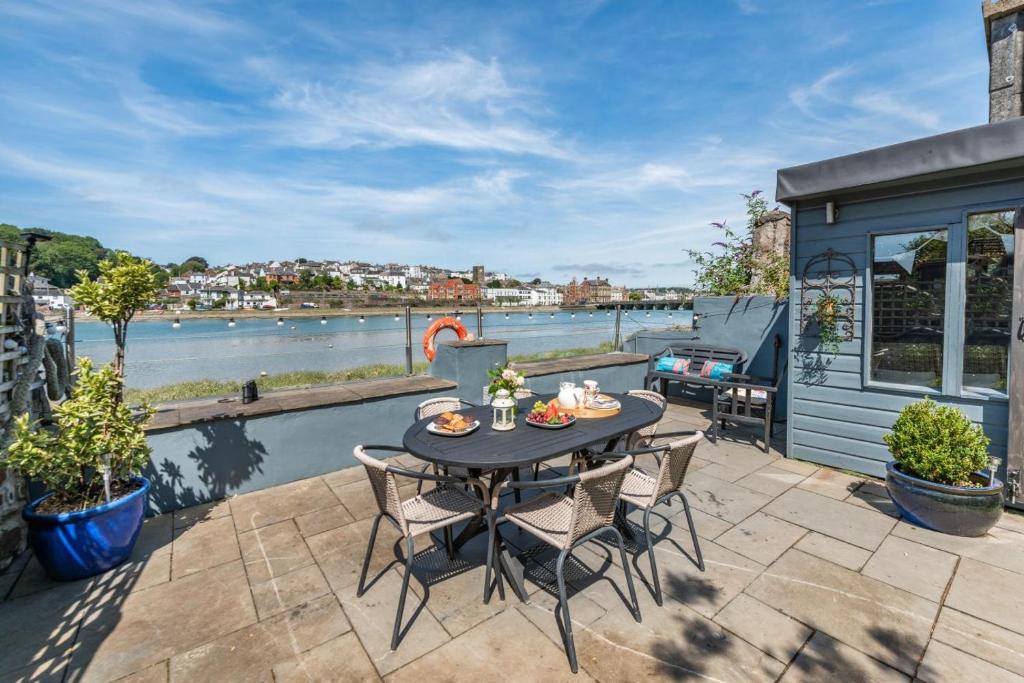 a patio with a table and chairs overlooking a river at 3 Bed in Bideford oc-79552 in Bideford