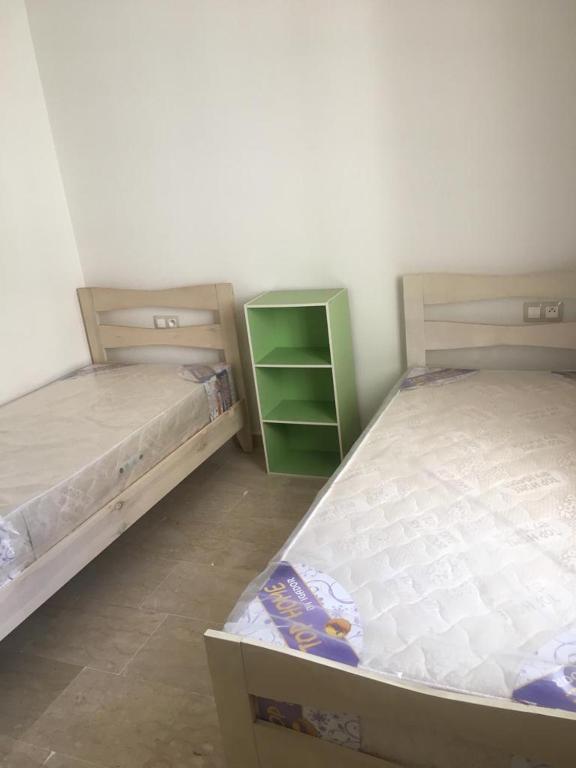 zwei Etagenbetten in einem Zimmer mit einem grünen Schrank in der Unterkunft Taj 3 in Nouaceur