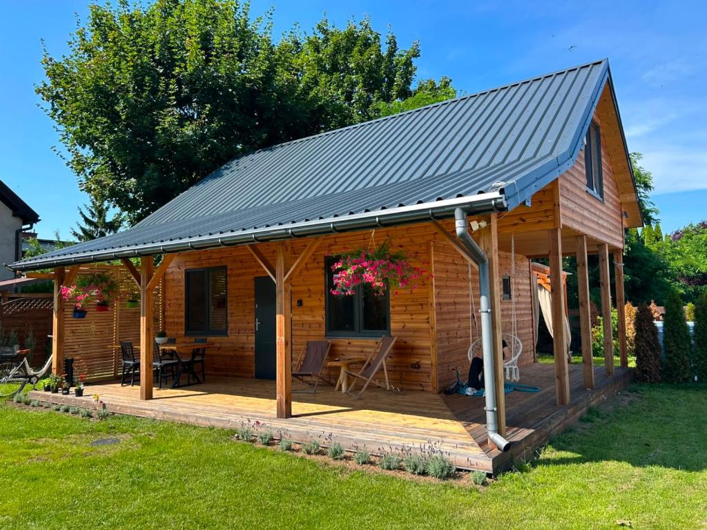 eine Holzhütte mit einem Metalldach in der Unterkunft Cicha Przystań Skępe 300 m od jeziora in Skępe