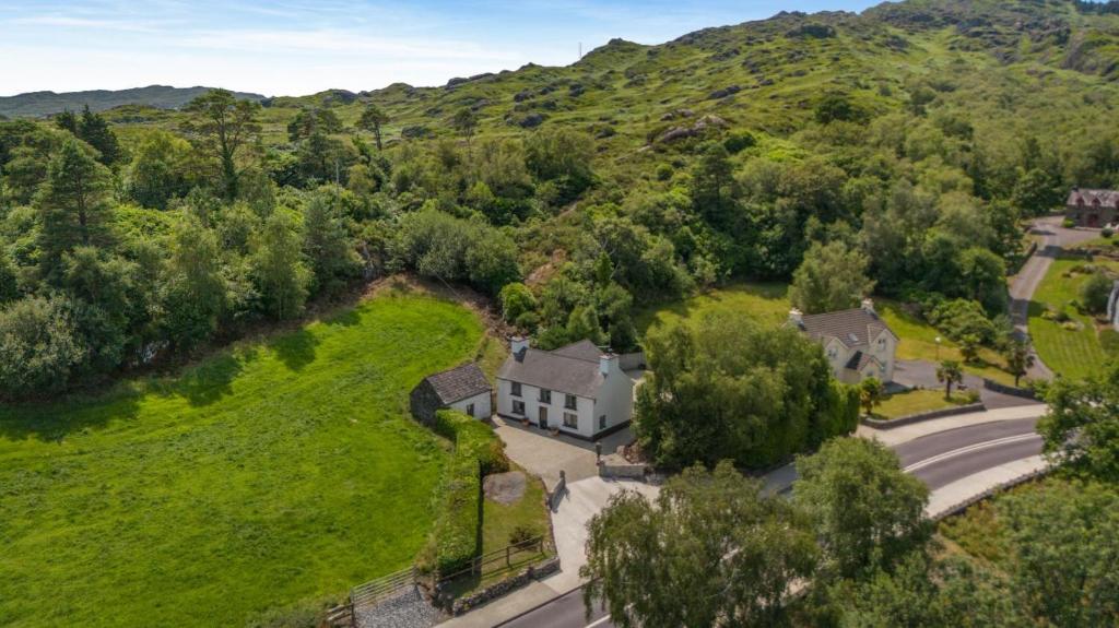 an aerial view of a house with a road and trees at 3 Bed in Glengarrff oc-i089 in Glengarriff