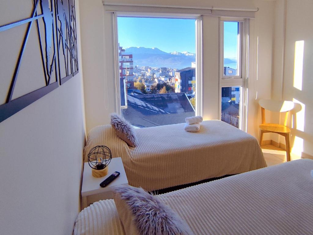 a room with two beds and a window with a view at Céntrico con vistas Ushuaiayvos in Ushuaia