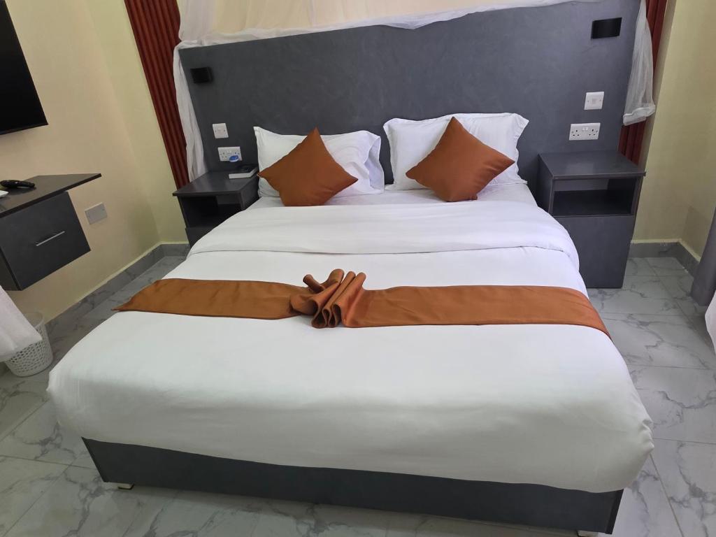 a large bed in a hotel room at The alder hotel and accommodation in Bungoma