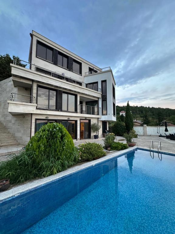 a house with a swimming pool in front of it at The Shefers Residence in Rogachevo