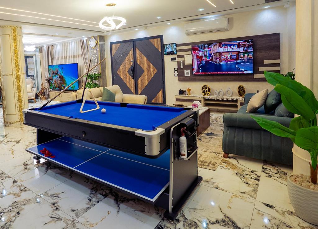 a living room with a pool table and a tv at Villa- Alahlam in Ghaţāţī
