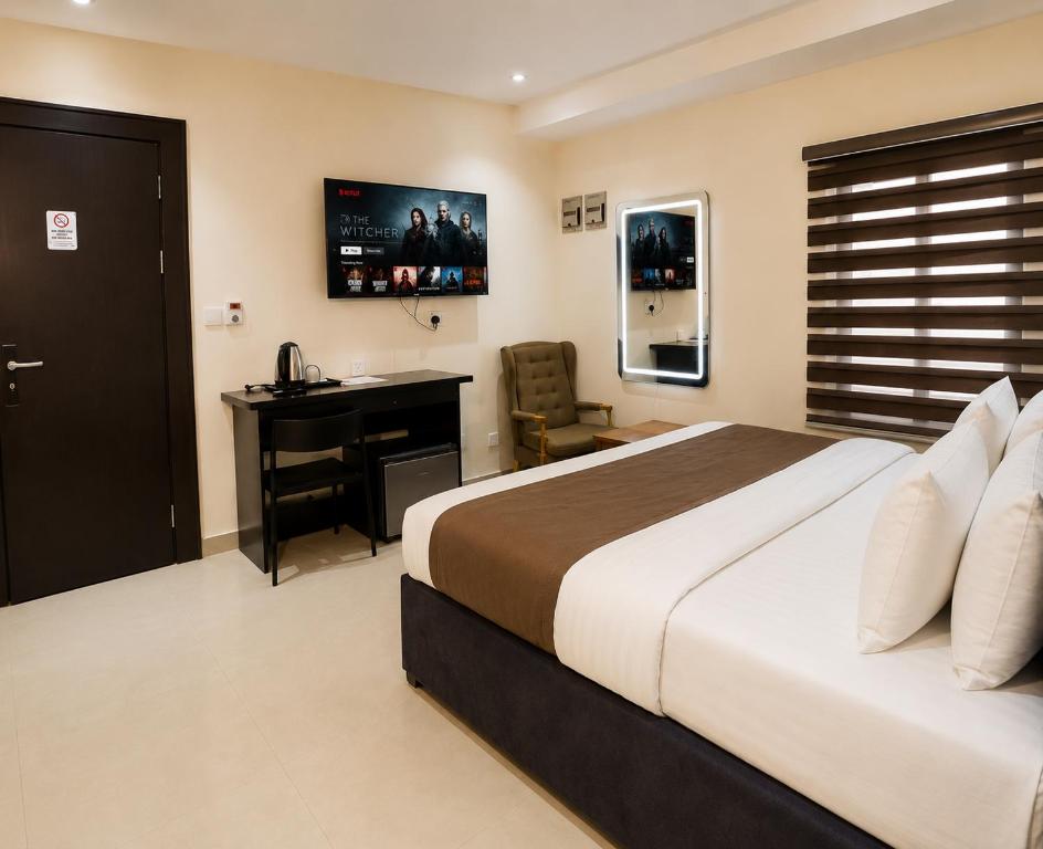a bedroom with a bed and a desk and a computer at Westside Beach Resort & Hotel in Mopo Akinlade