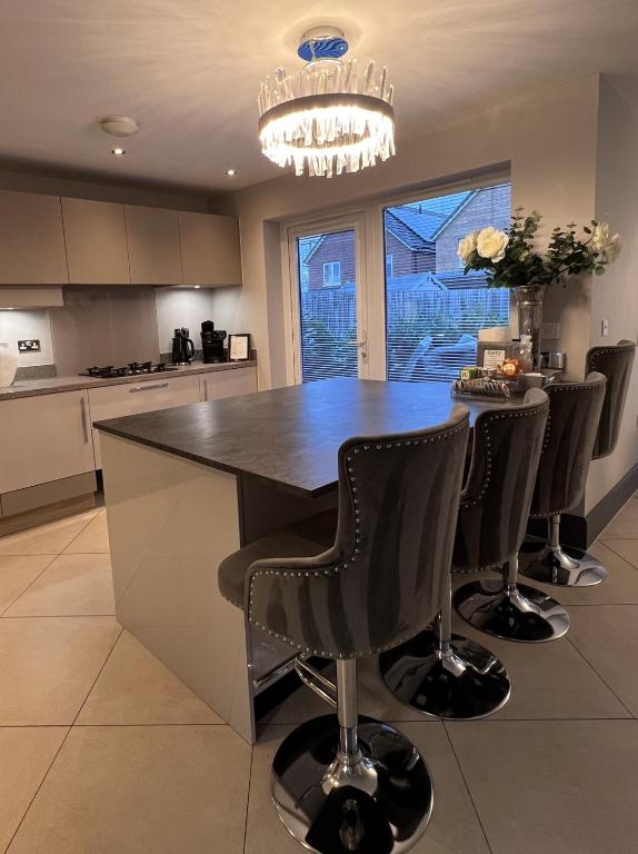 a kitchen with a table with chairs and a chandelier at Luxury Durham Home, Sleeps up to 12, Free Parking in Durham