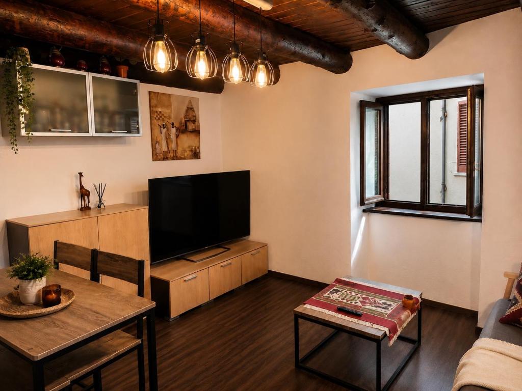 a living room with a flat screen tv and a table at La Baita Delle Due Valli in Maccagno Superiore