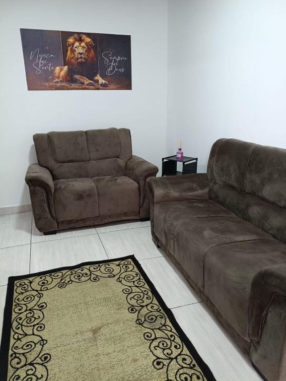 a living room with a brown couch and a rug at Casa com churrasqueira – Próx. Shopping Comércios in Várzea Paulista
