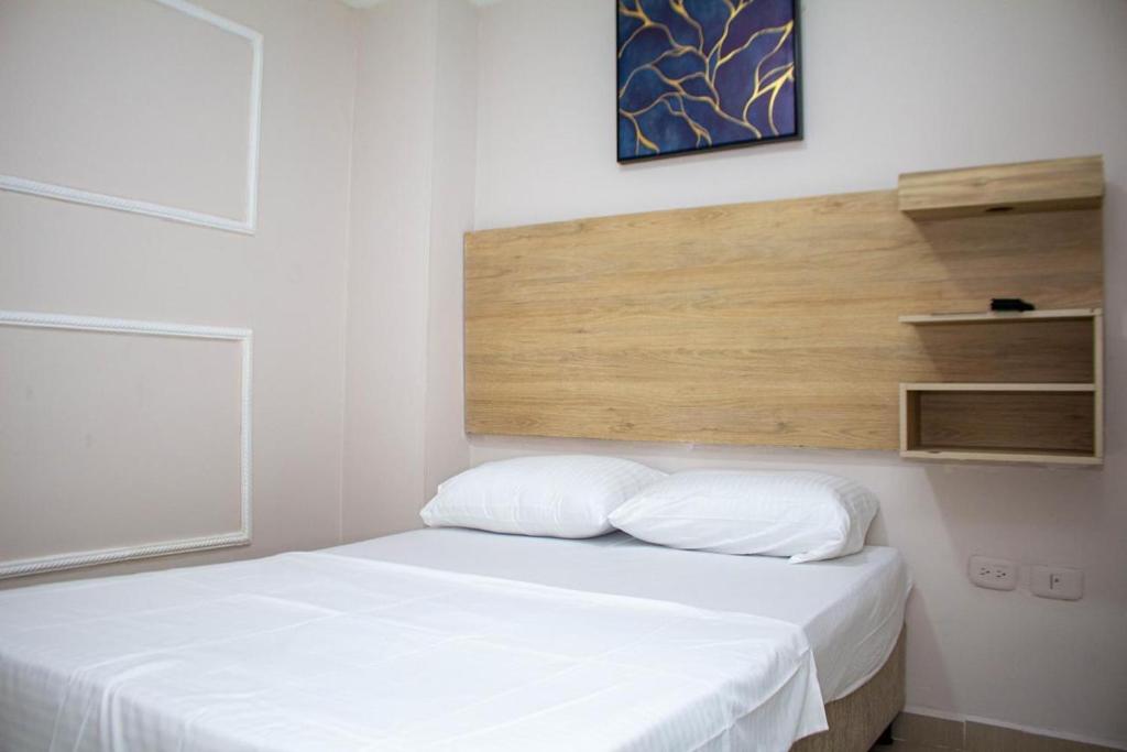 a white bed with two pillows in a room at Hospedaje GRAND horizon Rodadero, Santa Marta in Santa Marta