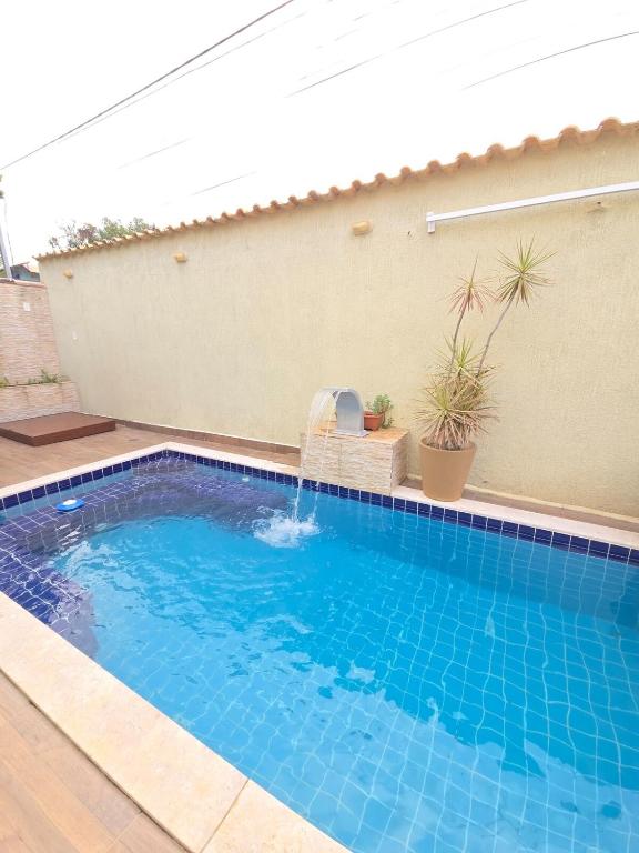 a swimming pool with a fountain in a backyard at Anexo da Paz Tucuns Búzios in Búzios