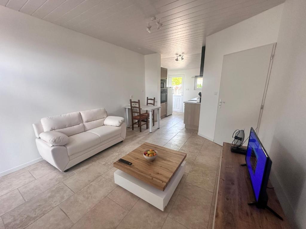 a living room with a white couch and a table at Le petit rêve in Fours