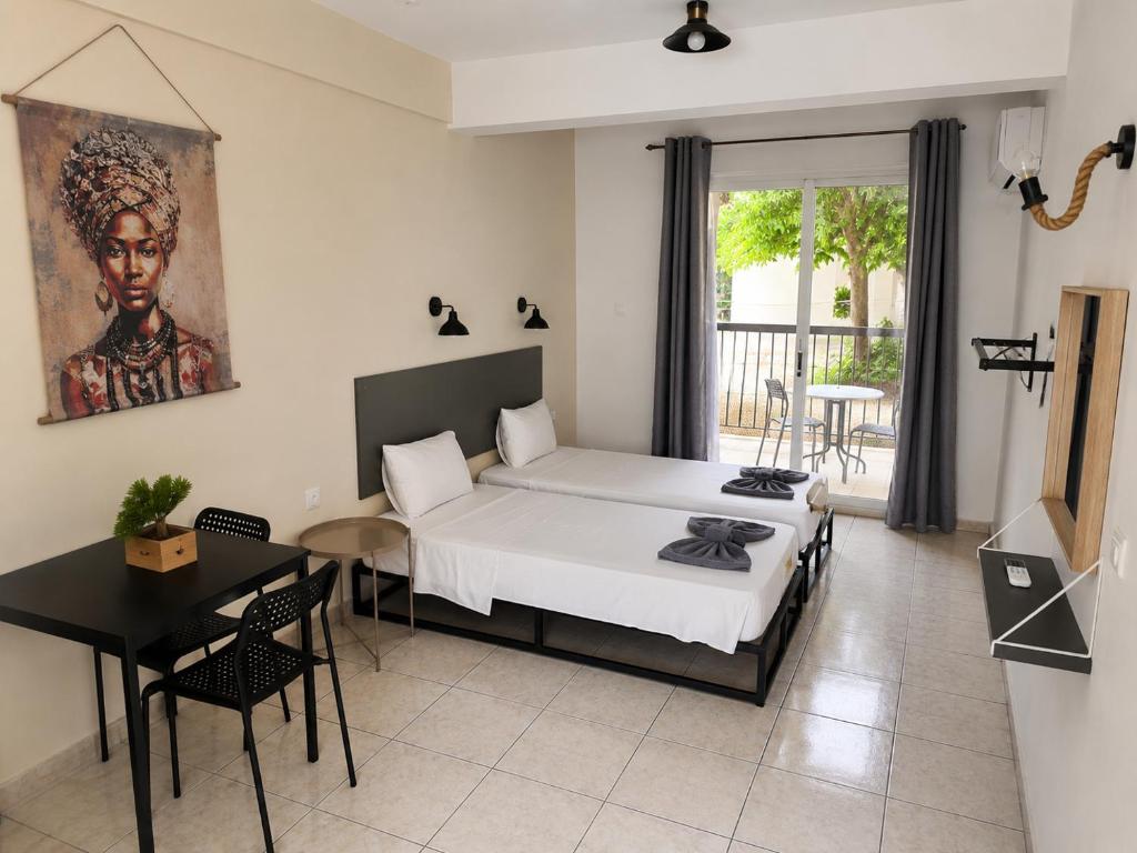 a bedroom with a bed and a table and a dining room at Summer's Hotel Apartments in Ayia Napa