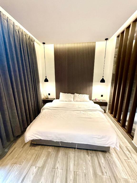 a bedroom with a large bed with white sheets at شاليهات سمو بارك 2 in Taif