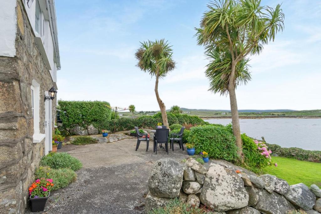 a patio with palm trees next to a house at 2 Bed in Cashel oc-i223 in Moyrus