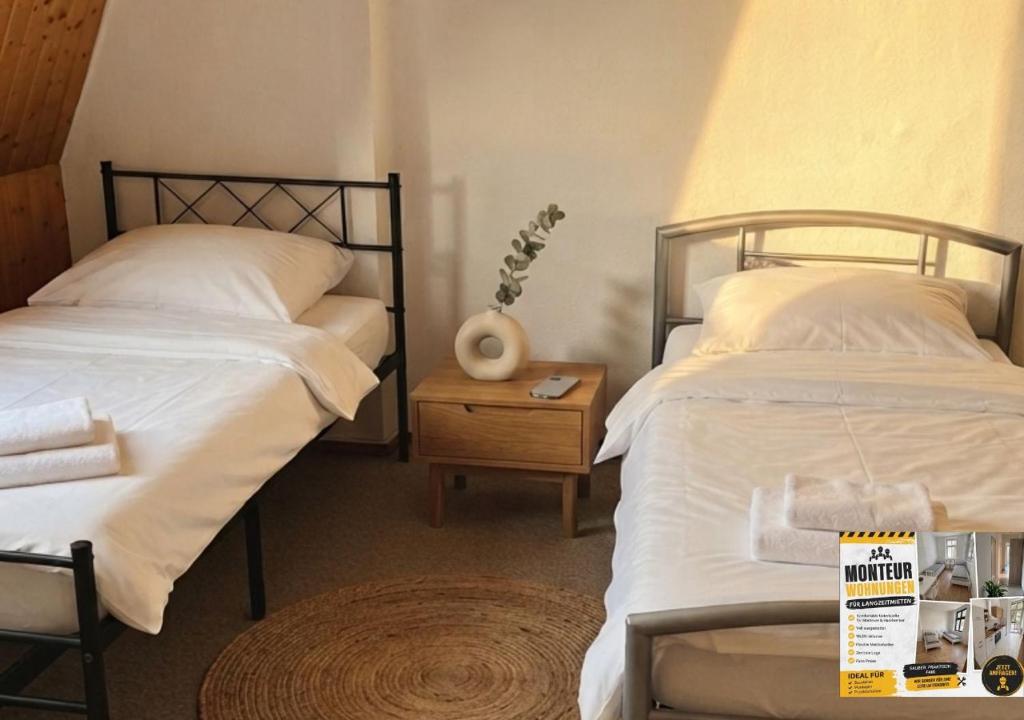 a bedroom with two beds and a table with a sign on it at Harzer Monteurs-Lounge Domschatz-Nähe in Halberstadt