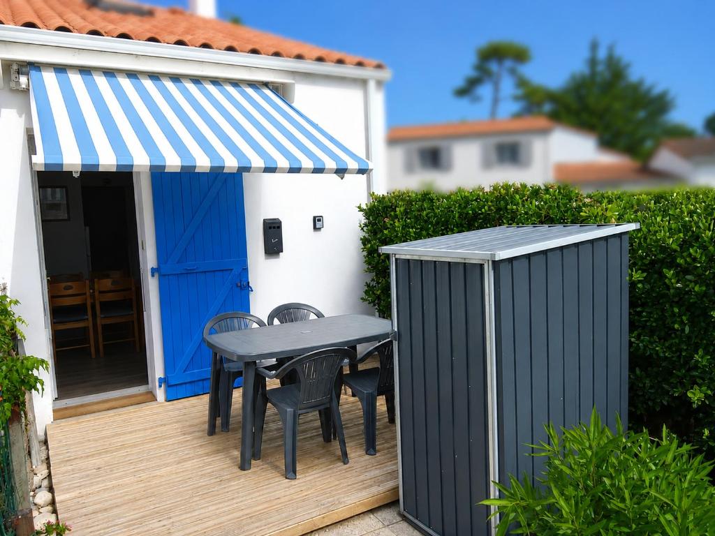 a table and chairs on a deck with a shed at Atlantique 165 in La Faute-sur-Mer