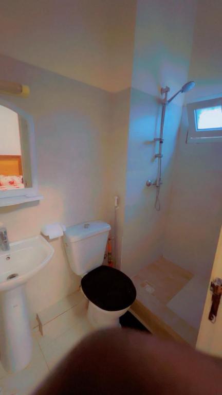 a bathroom with a white toilet and a sink at Kaila 1 in Keur Massar