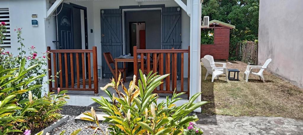 a house with a porch with a table and chairs at 36 Baltazia, 2 Ch 2 Pers-Clim jardin terrasse à Sainte-Anne in Sainte-Anne