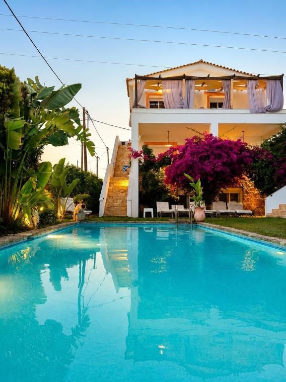 a house with a swimming pool in front of a house at Michaella's Maissonete at Rafaella Resort in Kokóni