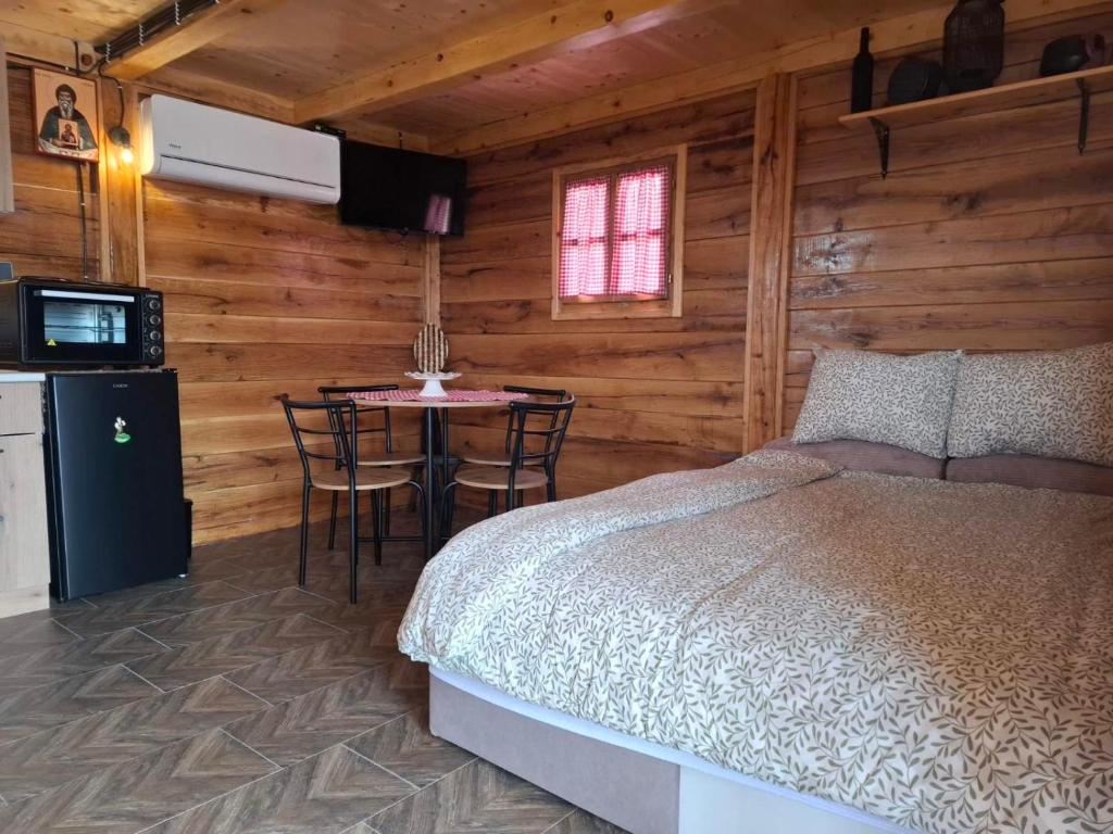 a bedroom with a bed and a table with chairs at Brvnara Mia in Rudnik