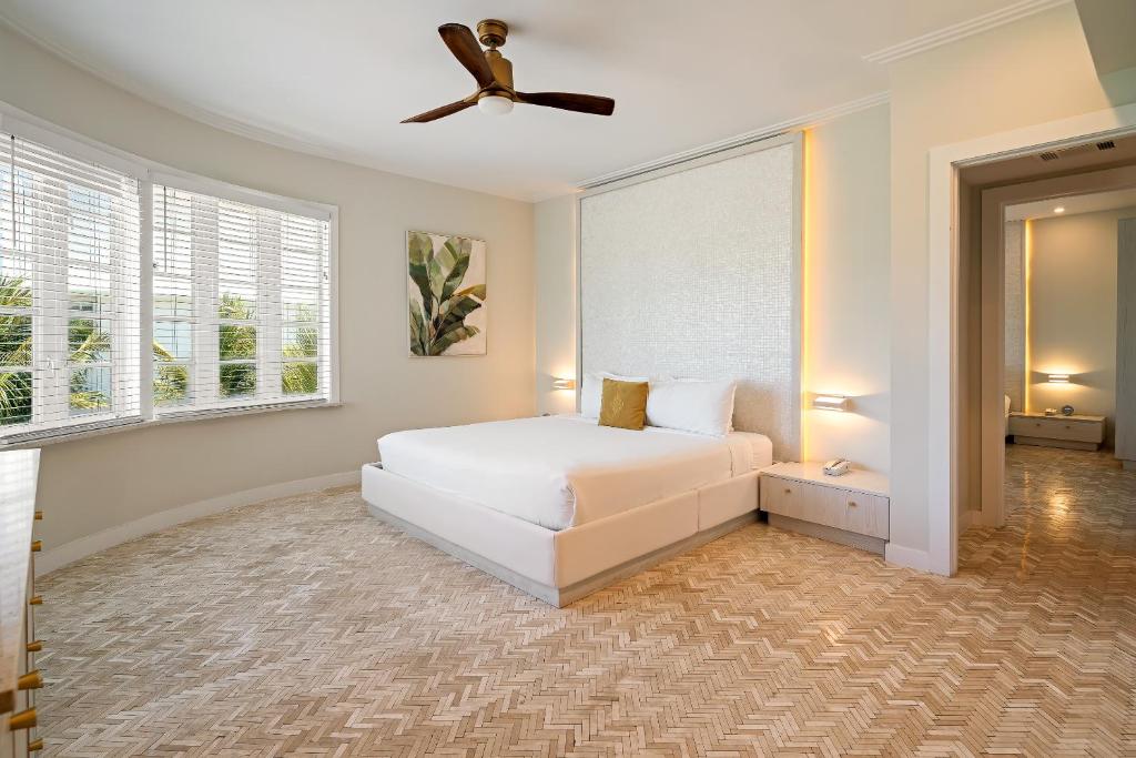 a bedroom with a white bed and a ceiling fan at Cardozo Hotel in Miami Beach