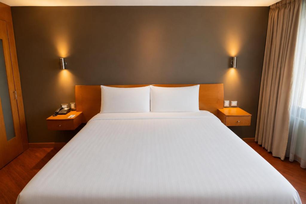 a bedroom with a large white bed with two night stands at El Dorado Hotel in Cuenca